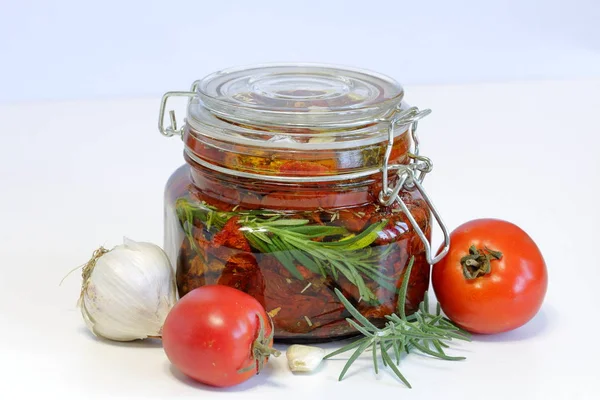Tomates secos ao sol com temperos e alho em um jarro. Perto de alecrim, tomates e alho . — Fotografia de Stock