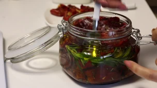 Woman Straightens Spoon Dried Tomatoes Jar Has Branch Rosemary Garlic — Stock Video