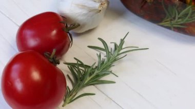 Masada domates, biberiye ve sarımsak vardır. Kurutulmuş domates konservesinin yanında. Baharatlar ve zeytinyağı eklenir..