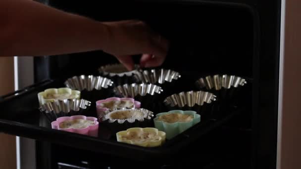 女性は焼いたケーキのブランクをオーブンから皿の上に移す フォームがベーキング シート上にある — ストック動画