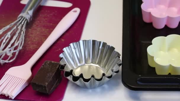 一个女人躺在桌上做甜点的工具 硅胶和金属蛋糕烤盘 糕点刷 烹饪甜点 — 图库视频影像