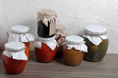 Ev yapımı mevsimlik preparatlar. Bankalarda, konserve sebzeler, meyveler. Kankaların boynu kağıda sarılır ve halatla bağlanır..