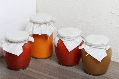 Ev yapımı mevsimlik preparatlar. Bankalarda, konserve sebzeler, meyveler. Kankaların boynu kağıda sarılır ve halatla bağlanır..