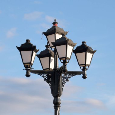 Vintage tarzda parkta Fener. Mavi gökyüzünün arka planında.