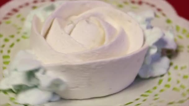 白色棉花糖的形状为玫瑰 带花瓣躺在花边餐巾上 围绕垂直轴旋转 — 图库视频影像