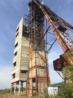 Mavi gökyüzüne karşı terk edilmiş bir madenin kalıntıları.