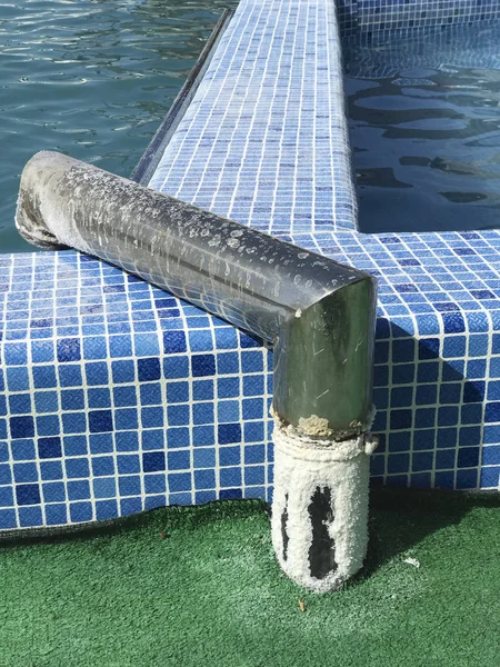 El complejo de los lagos de sal. El agua salada en la piscina brilla al sol. A los lados de la piscina sal seca visible del agua. Una tubería de suministro de agua recubierta de sal es visible . —  Fotos de Stock