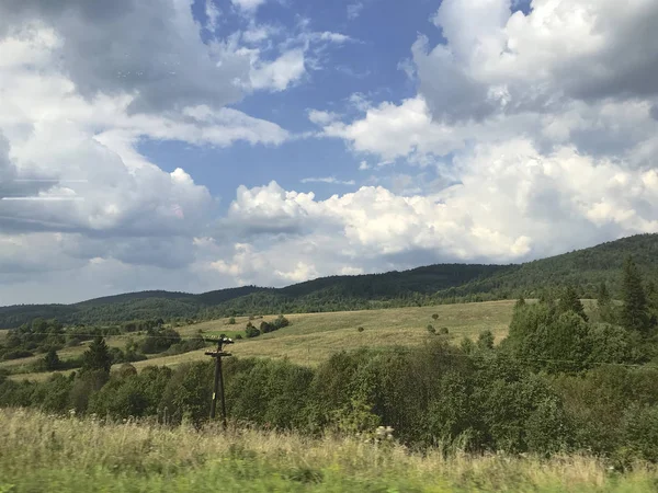 Górskie krajobrazy Zakarpacia. Widoczne wzgórza pokryte lasem, trawą. — Zdjęcie stockowe