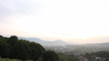 Dağ vadisi. Gün batımında. Vadide görünür yerleşim.