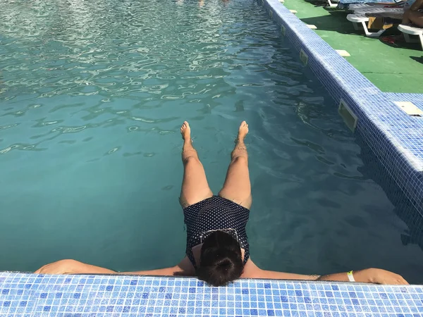 Menina na piscina ao ar livre. Apoiado a bordo da piscina. Sorrindo, óculos de sol na cabeça . — Fotografia de Stock