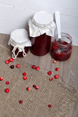 Ev yapımı reçeller, kavanozlarda kızılcık reçeli. Bir açık olabilir, bir çay kaşığı vardır. Birkaç çilek yüzeye serpilir.