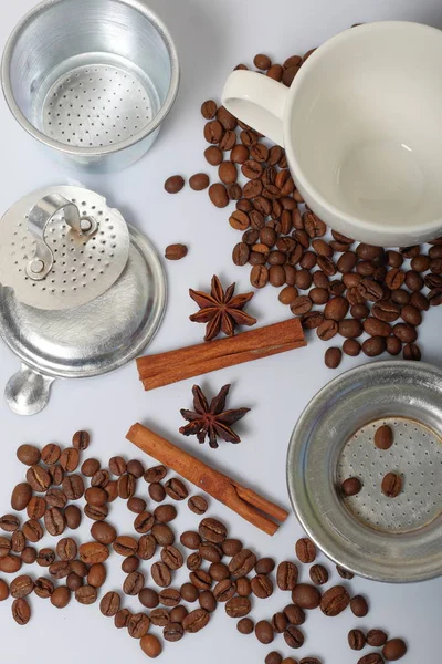 Granos de café, palitos de canela, pimienta de Jamaica y anís. Cerca de una taza blanca. Sobre fondo blanco. Día Mundial del Café . — Foto de Stock