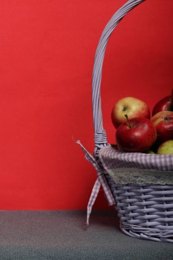 Olgun sulu elma ile Hasır sepet. Yeni mahsul. Mercan arka planında.