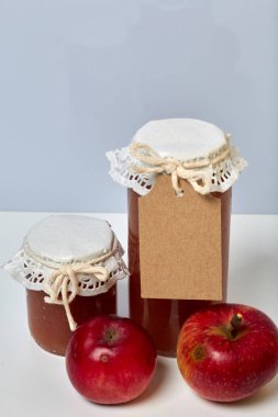 Ev yapımı mevsimlik preparatlar. Elma reçeli güzel paketlenmiş kavanoz. Kağıtla kaplanmış ve bir kordonla bağlanmış. Yakınlarda taze elmalar var..