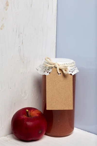 Preparações sazonais caseiras. Belamente embalados jarros de engarrafamento de maçã. Coberto com papel e amarrado com um cordão. Perto estão maçãs frescas . — Fotografia de Stock