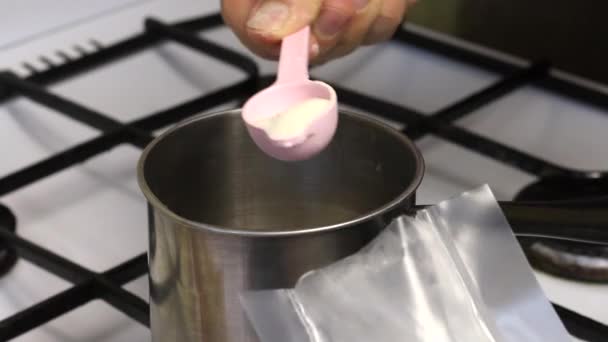 一个男人在炖锅里加琼脂 糖和煮糖浆用的水 用于制作棉花糖 — 图库视频影像