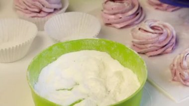 Bir kadın şekerlemelere dekstroz ile davranır. Tatlı hazır, masada yatıyor..