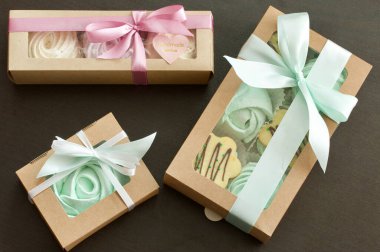 Farklı şekil ve renkte şekerlemeler. Kağıt ambalajda yığılmış. Renkli saten kurdelelerle bağlanmış..