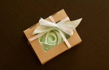 Farklı şekil ve renkte şekerlemeler. Kağıt ambalajda yığılmış. Renkli saten kurdelelerle bağlanmış..