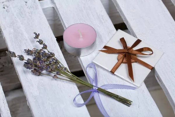 리본으로 묶은 라벤더 꽃다발 이 나무 상자 위에 놓여 있다. 근처에 인사장 이 있고 촛불이서 있다. — 스톡 사진