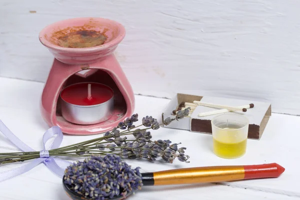 A bunch of lavender for aromatherapy and plant flowers in a spoon. Nearby is the aroma lamp. Oil is poured into the cap. Natural pharmacy. Aromatherapy with natural oils.