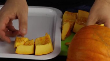 Bir adam portakal kabağını tepsiye koyar. Dünya Vejetaryen Günü.