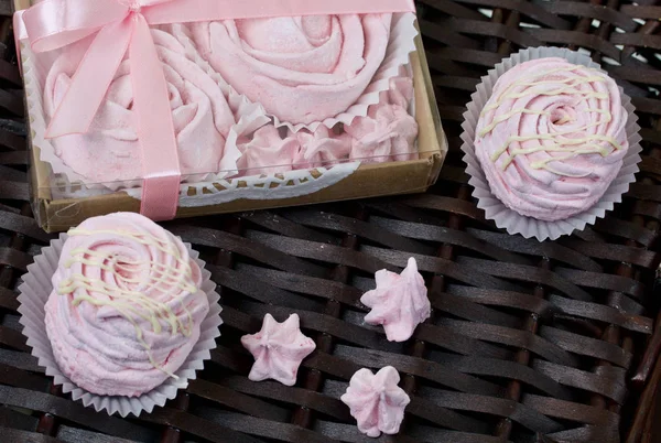 Malvaviscos de cereza rosados aéreos. En una caja de regalo con una cubierta transparente. Cerca de los malvaviscos sin embalaje. En el contexto de las vides de mimbre . — Foto de Stock