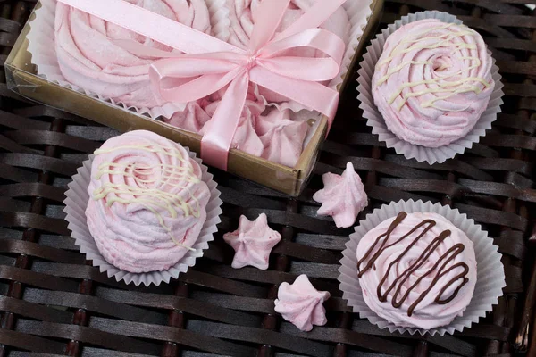 Malvaviscos de cereza rosados aéreos. En una caja de regalo con una cubierta transparente. Cerca de los malvaviscos sin embalaje. En el contexto de las vides de mimbre . — Foto de Stock