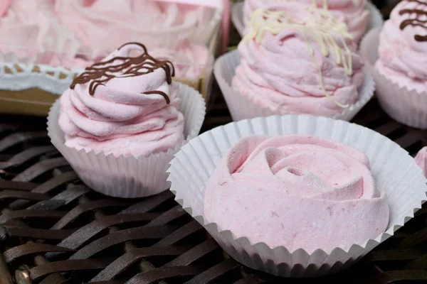 Guimauves cerises roses aériennes. Certains en forme de rose, un autre décoré de chocolat. Sur fond de vignes en osier . — Photo