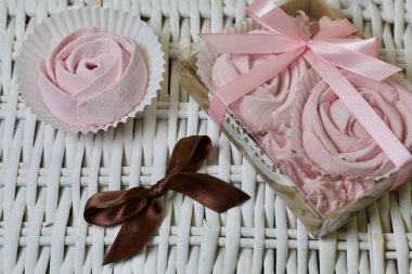 Havadan gelen vişneli şekerlemeler. Bir gül şeklinde olsun. Şeffaf kapaklı bir hediye kutusunda. Hasır asmaların arka planına karşı.