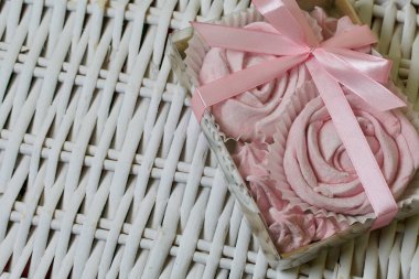 Havadan gelen vişneli şekerlemeler. Bir gül şeklinde olsun. Şeffaf kapaklı bir hediye kutusunda. Hasır asmaların arka planına karşı.