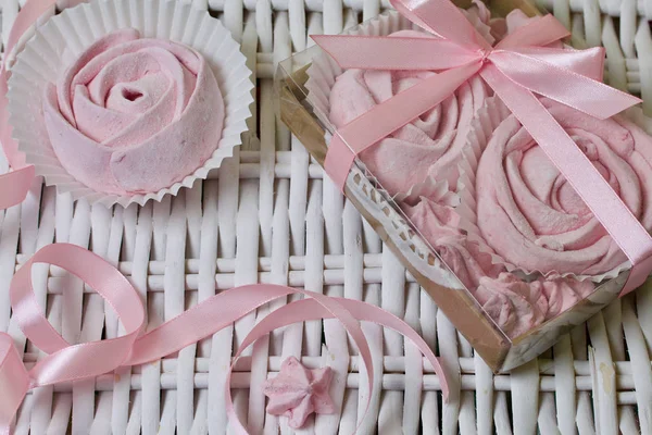 Aerial pink cherry marshmallows. In a gift box with a transparent cover. Near the marshmallows without packaging. Against the background of wicker vines. — Stock Photo, Image