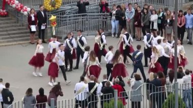 MINSK, BELARUS 29 MAYIS 2020 Okul Dansı mezunları bir vals. Erkekler ve kızlar son çağrıda. Misafirlerle çevrili..