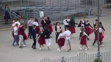 MINSK, BELARUS 29 Mayıs 2020 Okul mezunları bir veda valsi prova ediyorlar. Erkekler ve kızlar dansın unsurlarını icra ederler..