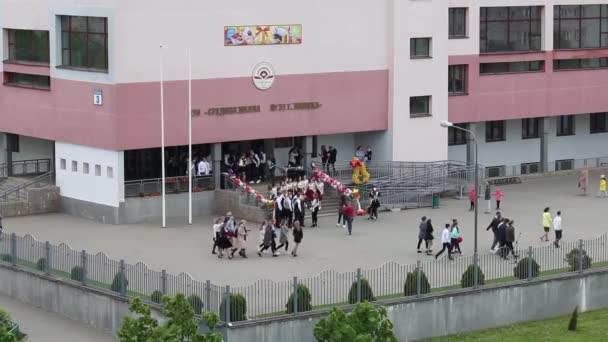 MINSK, BELARO 29 MAGGIO 2020 Ultima chiamata a scuola. I laureati camminano davanti all'ingresso decorato della scuola . — Video Stock