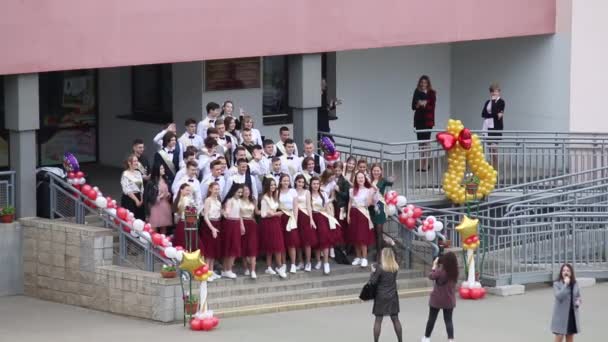 MINSK, BELARUS 29 mei 2020 Laatste oproep op school. Afgestudeerden maken foto 's op de trappen voor de ingang van de school — Stockvideo