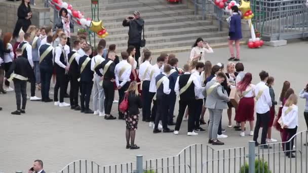 MINSK, BELARUS MAY 29, 2020最后一次在学校的拜访。排着臂章的毕业生站在学校前面. — 图库视频影像