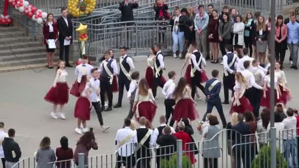 MINSK, BELARUS MAY 29, 2020 Los graduados de la escuela bailan un vals. Chicos y chicas en la última llamada. Rodeado de invitados . — Vídeo de stock