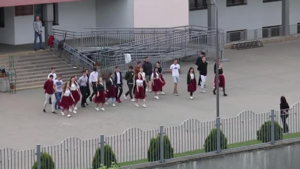 MINSK, BELARUS MAJ 29, 2020 Utexaminerade från skolan går ut i grupp för att repetera en skolvals. Pojkar och flickor gör sig redo för dansen. — Stockvideo