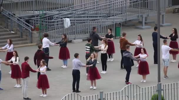 MINSK, BELARUS MAY 29, 2020 Випускники школи репетирують прощальний вальс. Хлопці і дівчата танцюють перед школою... — стокове відео