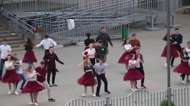 MINSK, BELARUS 29 Mayıs 2020 Okul valsi provası yapıyor. Erkekler ve kızlar okulun önünde dans ediyor.. — Stok video