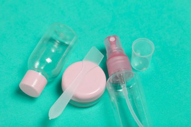 Çeşitli şekil ve boyutlarda kozmetik ürünleri için plastik şişe. Krema için kürek. Nane renginin yüzeyinde.