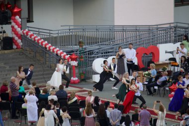 MINSK, BELARUS, 10 HAZİRAN 2020 lise mezunu. Mezunları okulun önündeki sitede vals yapıyor..