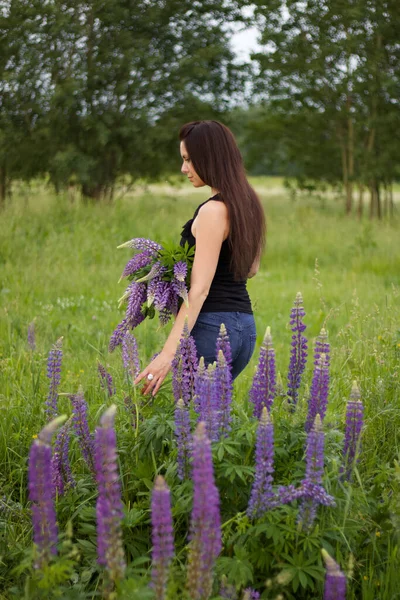 Ein Mädchen Mit Einem Strauß Lupinen Steht Auf Einer Wiese — Stockfoto