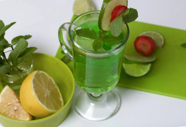 在杯子里放绿色柠檬水 用石灰和草莓装饰的用薄荷糖做的靠近柠檬和薄荷 — 图库照片