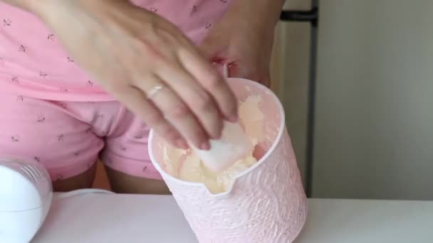 La mujer mezcla azúcar glaseado y queso crema. Hace el relleno. El proceso de hacer rollo suizo . — Vídeos de Stock