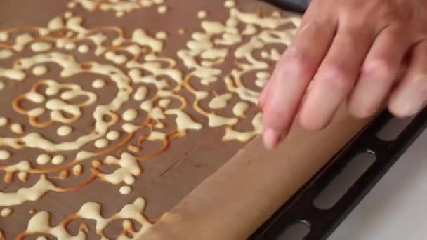 Une femme ajoute de la pâte aux épinards hachés et de la menthe sur une plaque à pâtisserie avec des motifs cuits au four. Le processus de fabrication du rouleau suisse. — Video