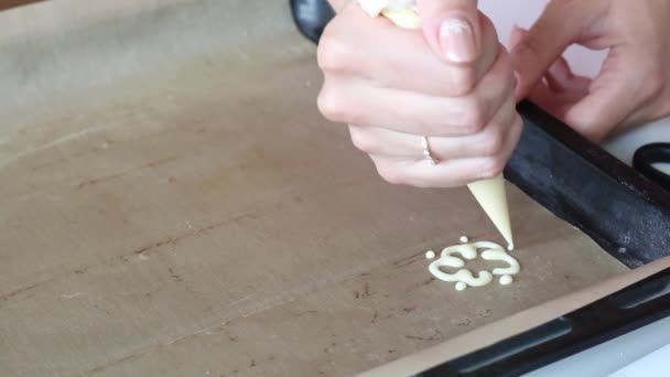Kobieta rysuje wzór ciasta na blasze do pieczenia. Proces produkcji rolki szwajcarskiej. — Wideo stockowe