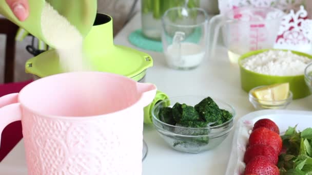 Vrouw in een suikerbakje en mengt de inhoud met een blender. Bereid een deeg voor het maken van Zwitserse roll. — Stockvideo