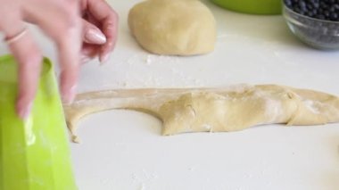 Bir kadın bardakla hamur tatlısı yapıyor. Hamurda gerekli şekli oluşturur. Hamur köftesi pişiriyorum. Yakın çekim.